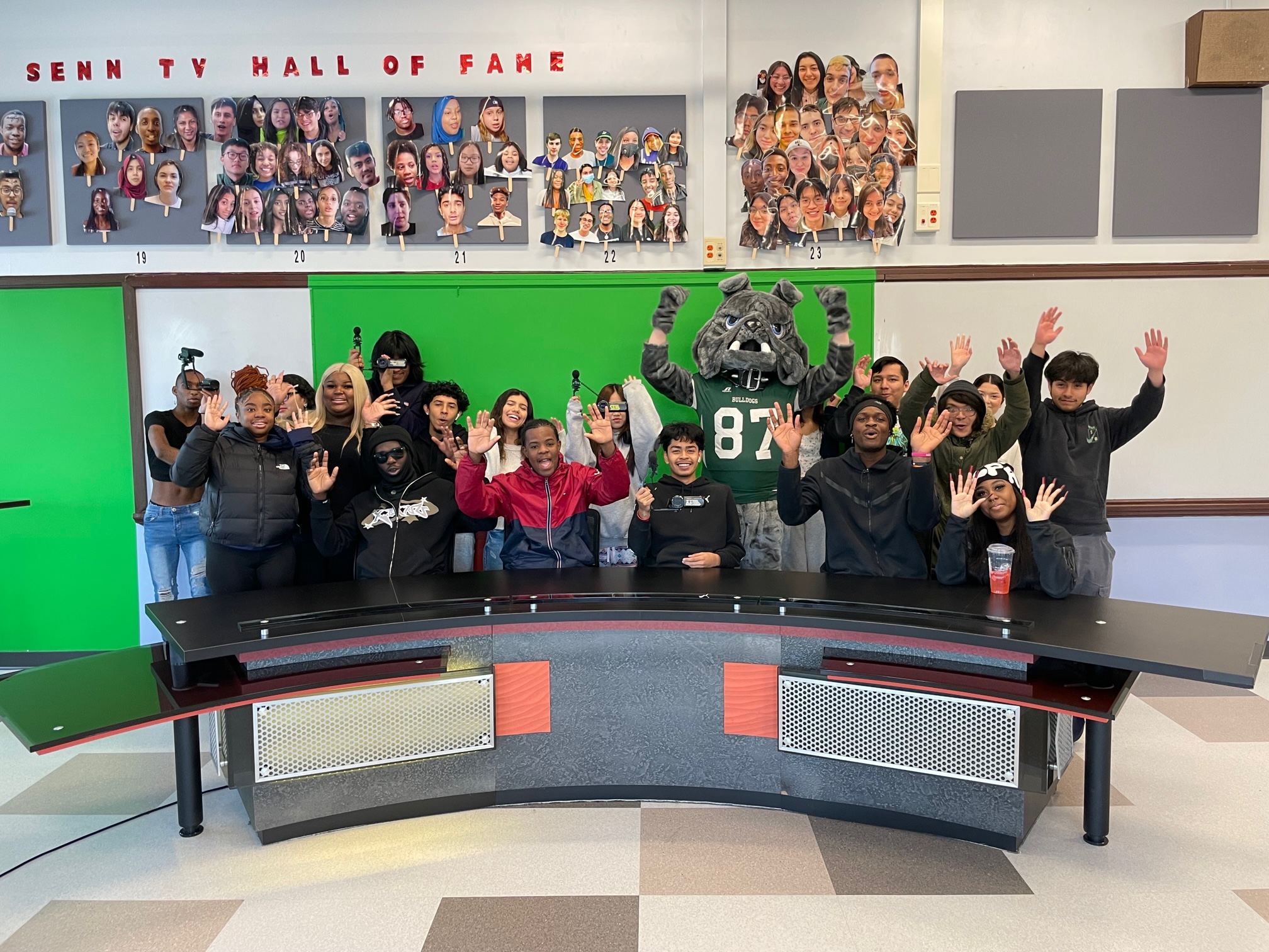 Students and the Bulldog mascot at Senn High School enjoy the anchor desk donated to the high school by the SOC. Photo by Jamason Chen.